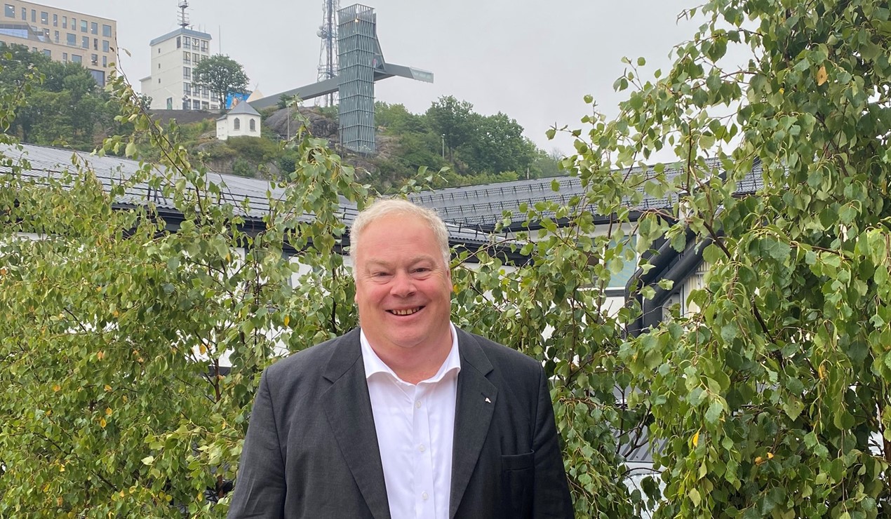 NBBLs Bård Folke Fredriksen på taket til Arendal Boligbyggelag - med glassheisen på toppen av Fløyheia i bakgrunnen. Også i år kan du treffe oss her, det skjer onsdag 14. august. Foto: NBBL