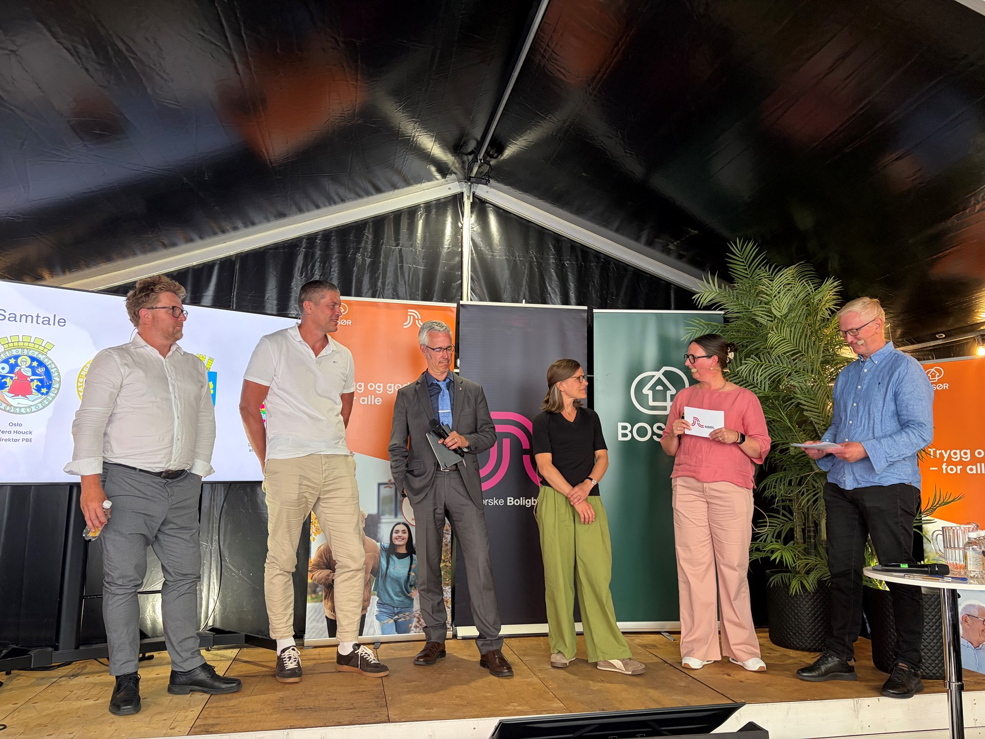 På scenen under NBBLs arrangement om Rett på byggesak: Ragnar Evensen fra Kristiansand kommune, Sven Norland fra Stavanger kommune, Tarje Iversen Wanvik fra Bergen kommune, og Vera Houck fra Oslo kommune. NBBLs Line Bjerkek og Ketil Krogstad ledet seansen. 